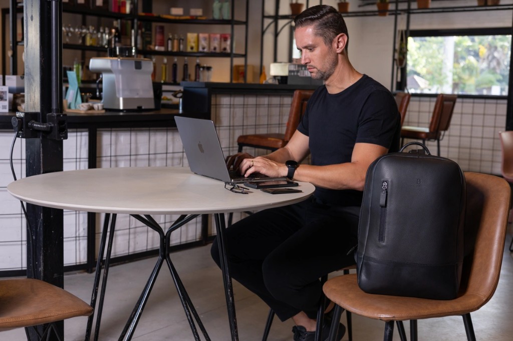 Homem com mochila de couro masculina Pelli Brasil em ambiente de trabalho
