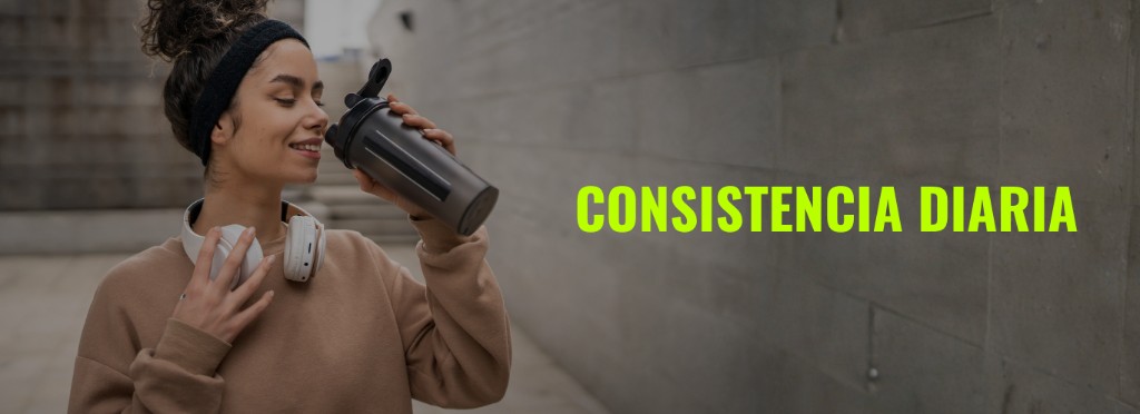Texto Alt: Mujer tomando creatina monohidrato en un shaker negro despu&eacute;s de entrenar para acelerar la recuperaci&oacute;n muscular.