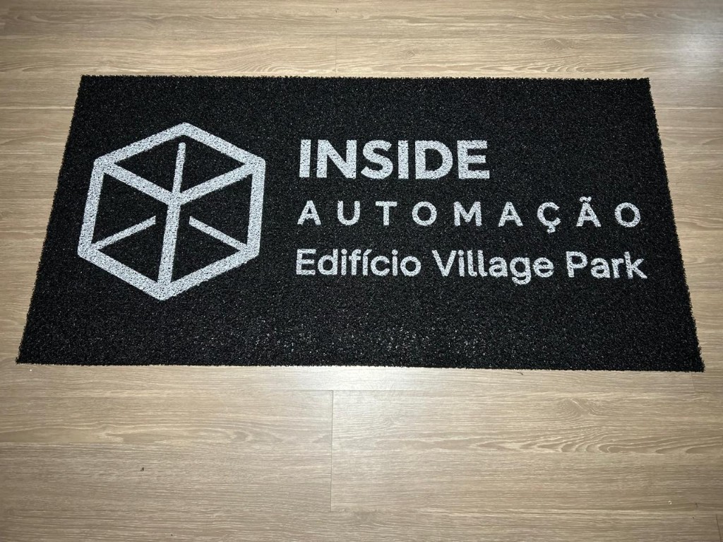 Capacho personalizado da Inside com logo e identidade da marca, instalado na entrada sobre piso premium, ideal para empresas e ambientes corporativos.