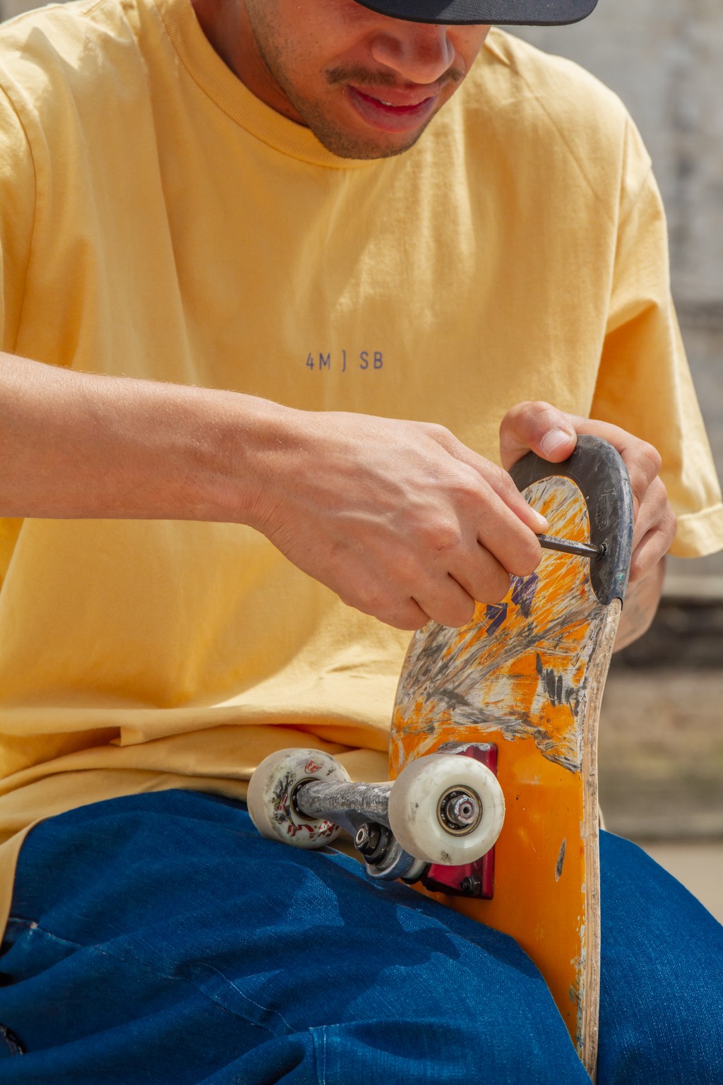 Skatista preparando o deck de skate antes do rol&ecirc;, ajustando o equipamento para garantir melhor desempenho e controle.