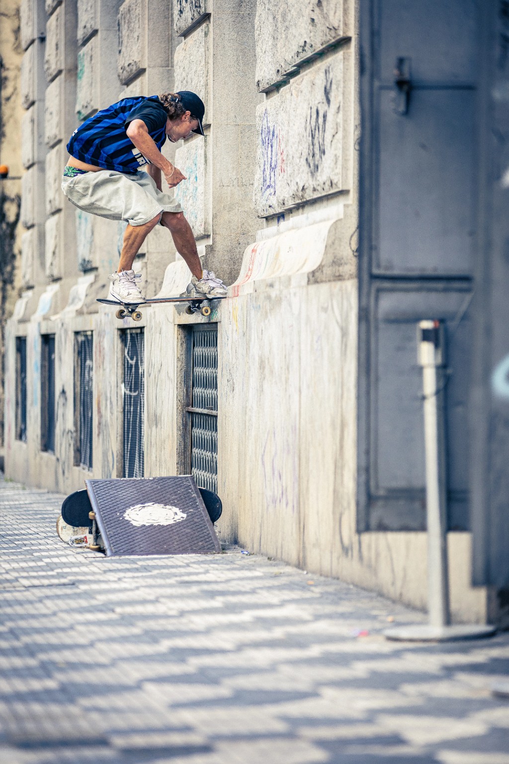 Skatista executando um frontside noseslide em uma borda alta de pedra na rua. Ele desliza o nose do skate no concreto, momento em que a proteção da tecnologia TIPtech no shape 4Msb atua para evitar o desgaste e a quebra da madeira.
