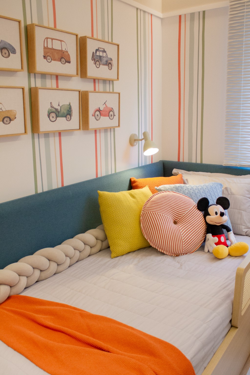 Cantinho de dormir do Bernardo com almofadas Rian em tons amarelo, laranja e azul