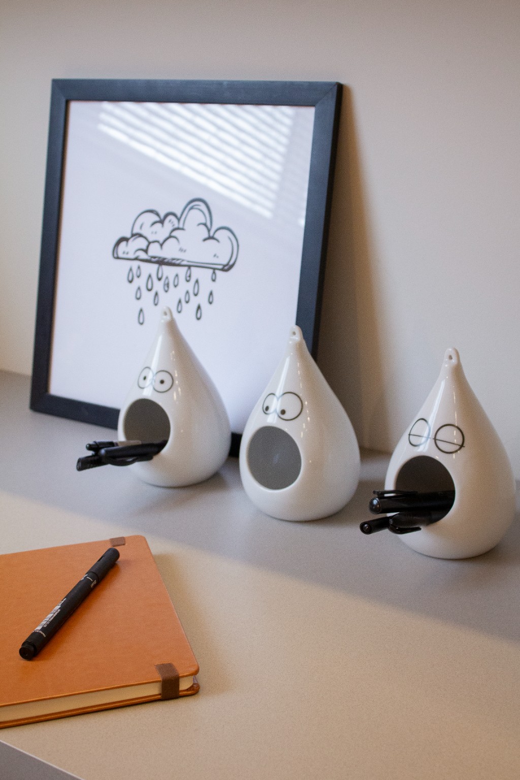 Vasinhos gota usados como porta-lápis sobre a mesa de estudos