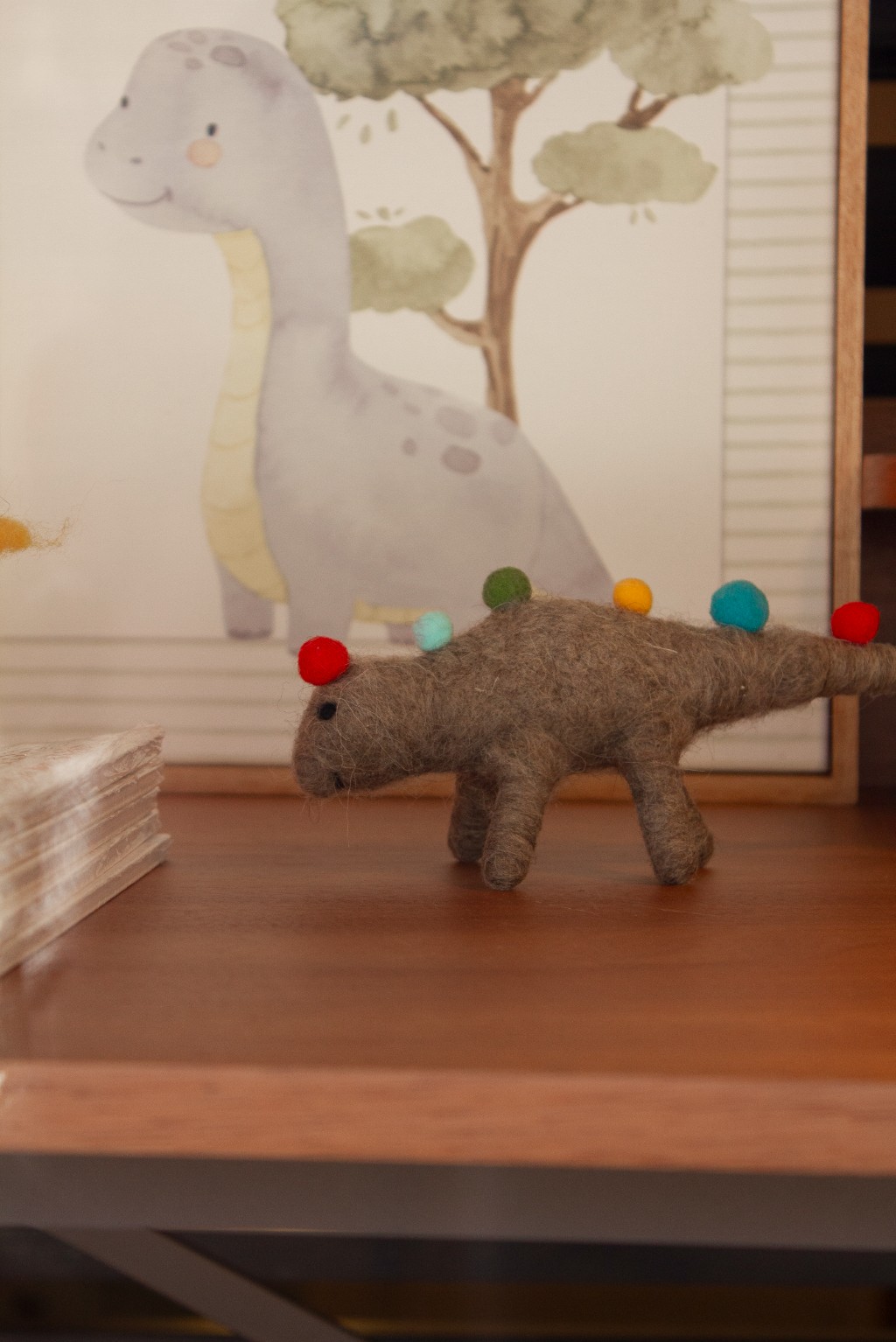 Dinossauro de l&atilde; decorativo infantil sobre escrivaninha