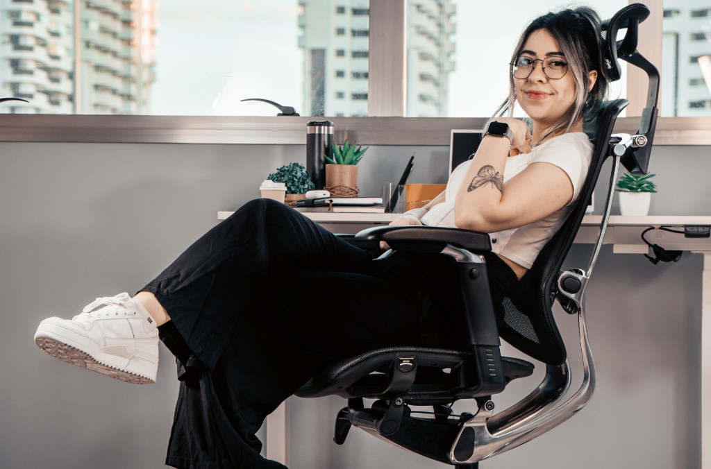 Cadeira Irina ambientada com modelo feminina em ambiente de escrit&oacute;rio