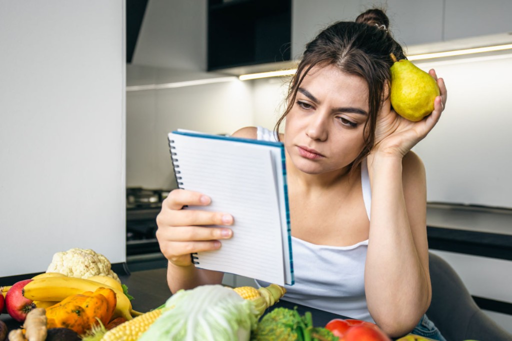 chica leyendo su dieta en una libreta