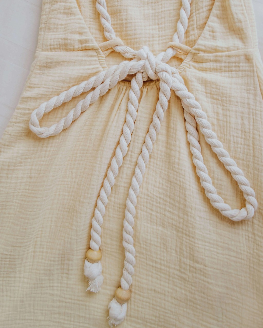 al&ccedil;as de cordas naturais com ponteiras de madeira em vestido de algod&atilde;o