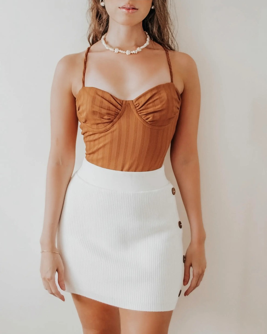 mai&ocirc; e body marrom de meia-ta&ccedil;a canelado com saia de tric&ocirc; canelada branca com bot&otilde;es de madeira