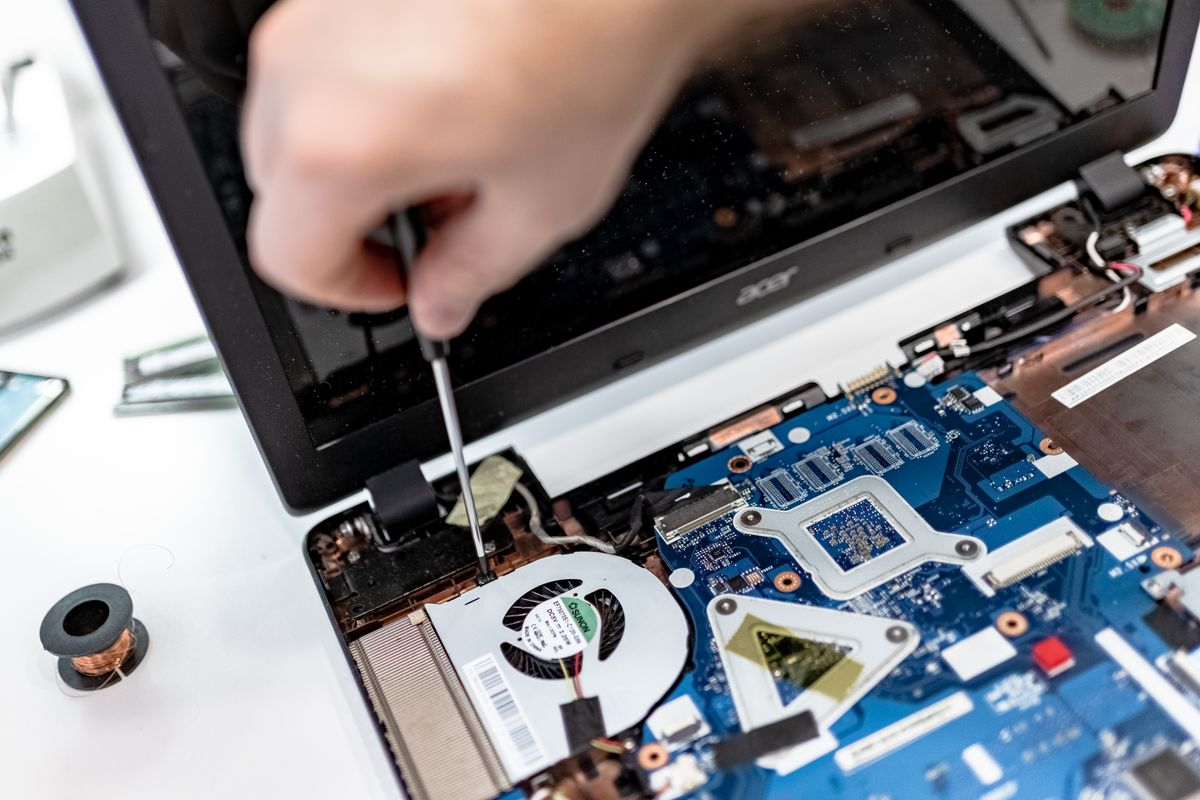 Técnico reparando motherboard de notebook