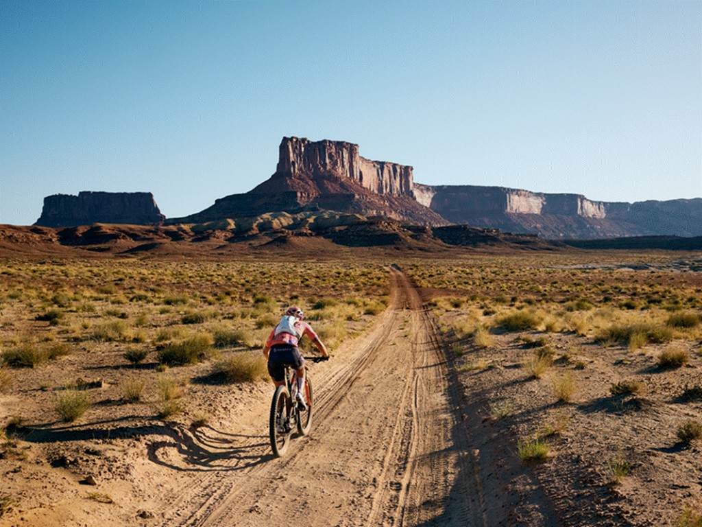 T&iacute;tulo: Imagem de destaque &mdash; ciclista de mountain bike pedalando em estrada de terra no deserto - Descri&ccedil;&atilde;o: Imagem de destaque &mdash; ciclista de mountain bike pedalando em estrada de terra no deserto