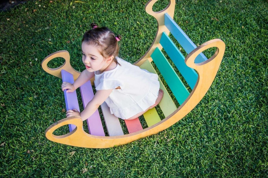 Vista cenital de una ni&ntilde;a jugando arriba del balanc&iacute;n Montessori