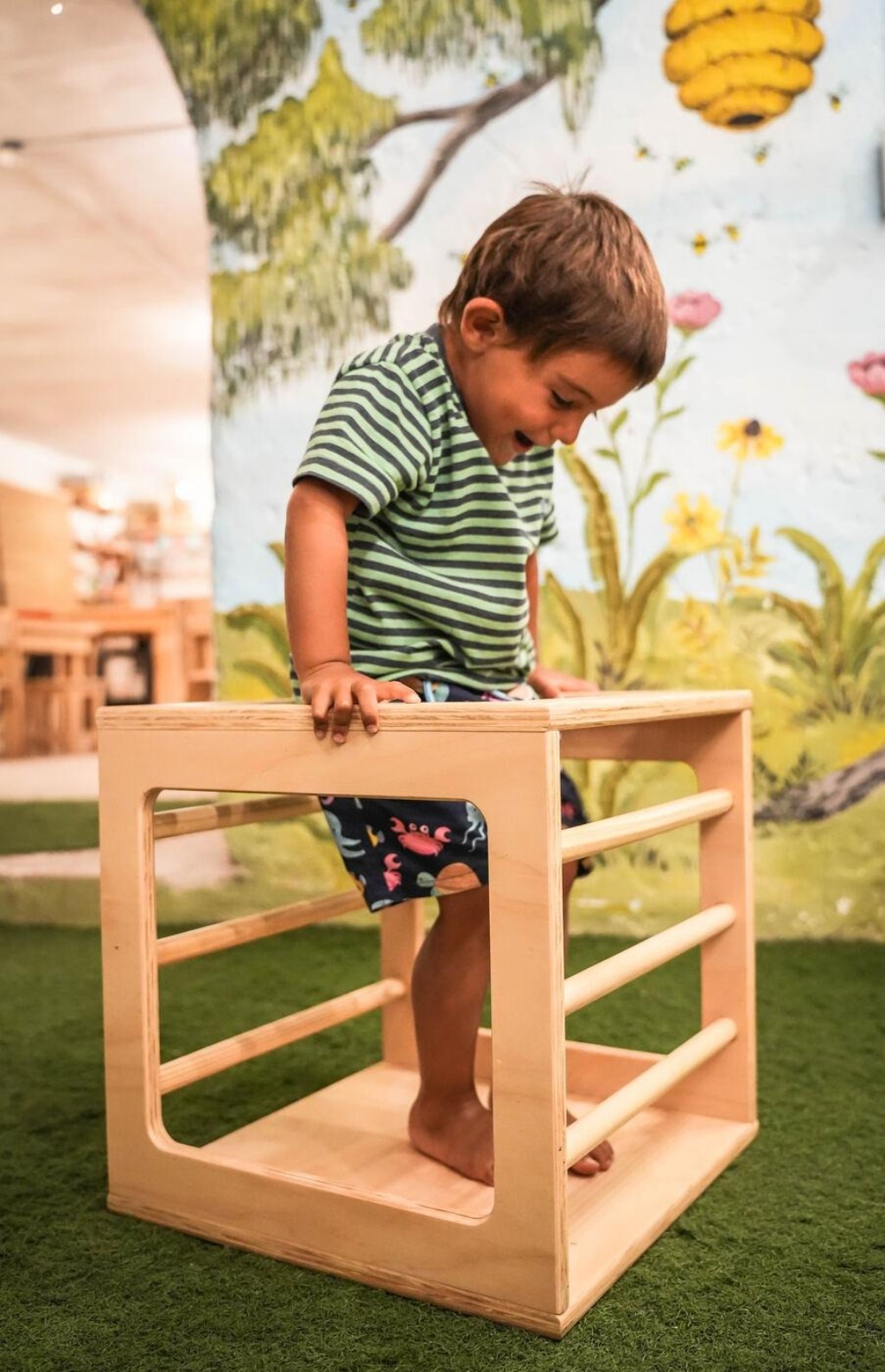  Ni&ntilde;o trepando arriba del cubo Pikler, riendo