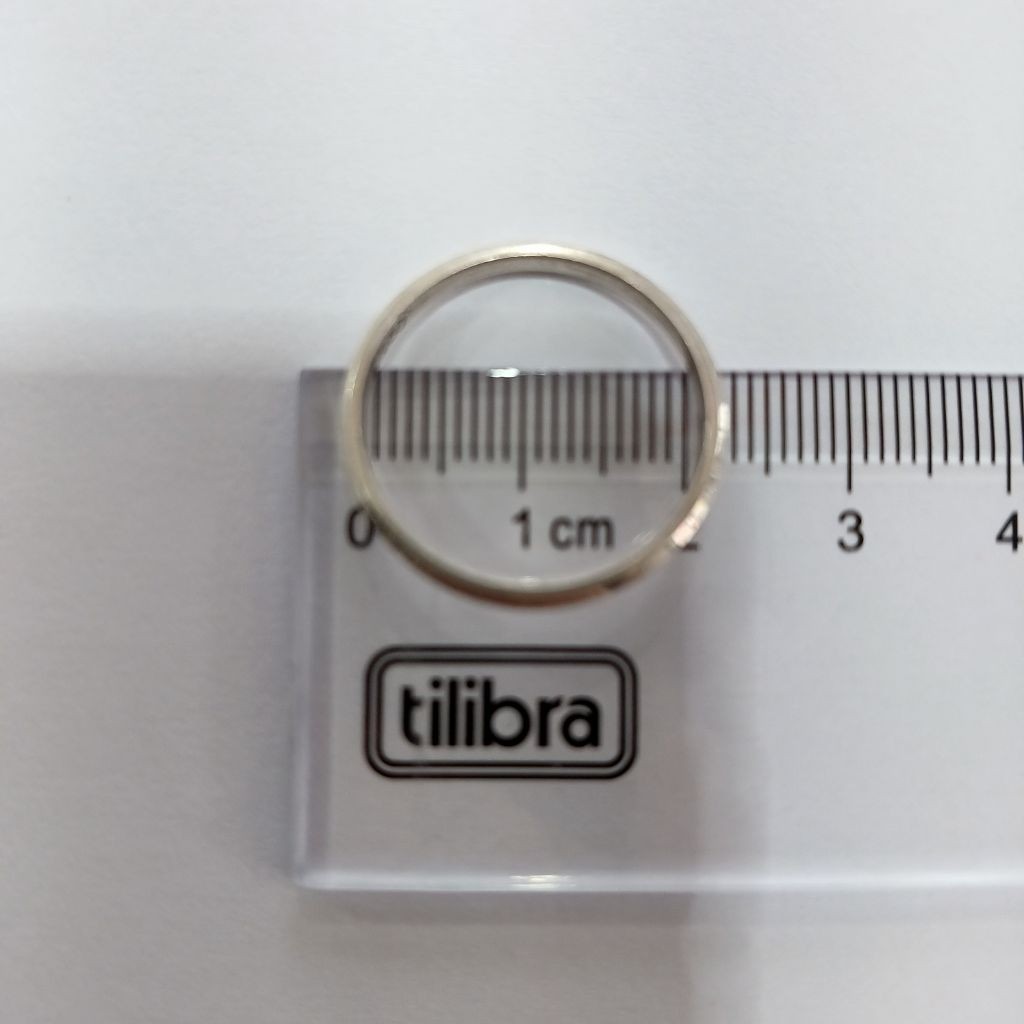 M&eacute;todo alternativo para saber o tamanho do anel: uma r&eacute;gua mede o di&acirc;metro interno de uma alian&ccedil;a de prata. A medida deve considerar apenas a parte de dentro do aro, ignorando as bordas de metal