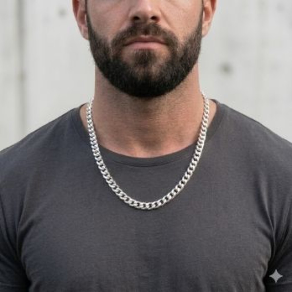 Homem com biotipo m&eacute;dio usando corrente de prata 925 de 50cm, modelo Grumet, rente &agrave; base do pesco&ccedil;o sobre camiseta cinza escura. Exemplo de caimento para o padr&atilde;o brasileiro.