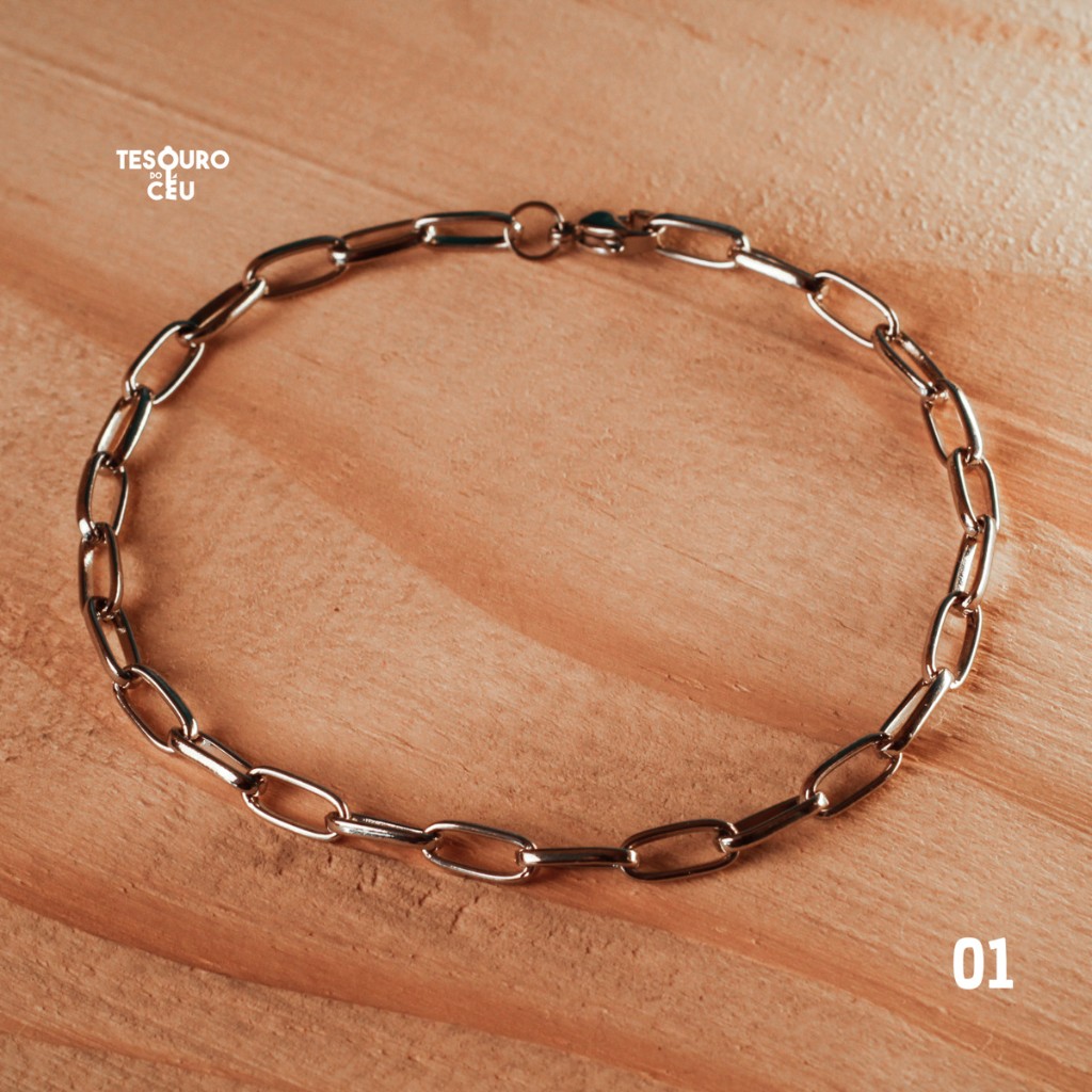 Pulseira de consagra&ccedil;&atilde;o Tesouro do C&eacute;u modelo 01, fotografada sobre madeira.