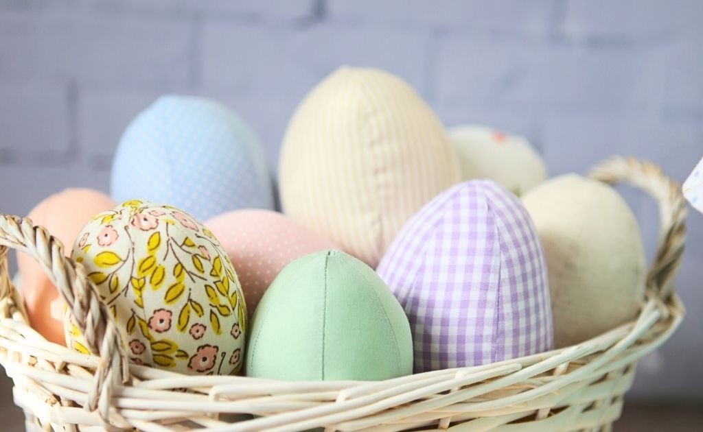 ovos de tecido colorido e fofinhos dentro de uma cesta branca para a p&aacute;scoa