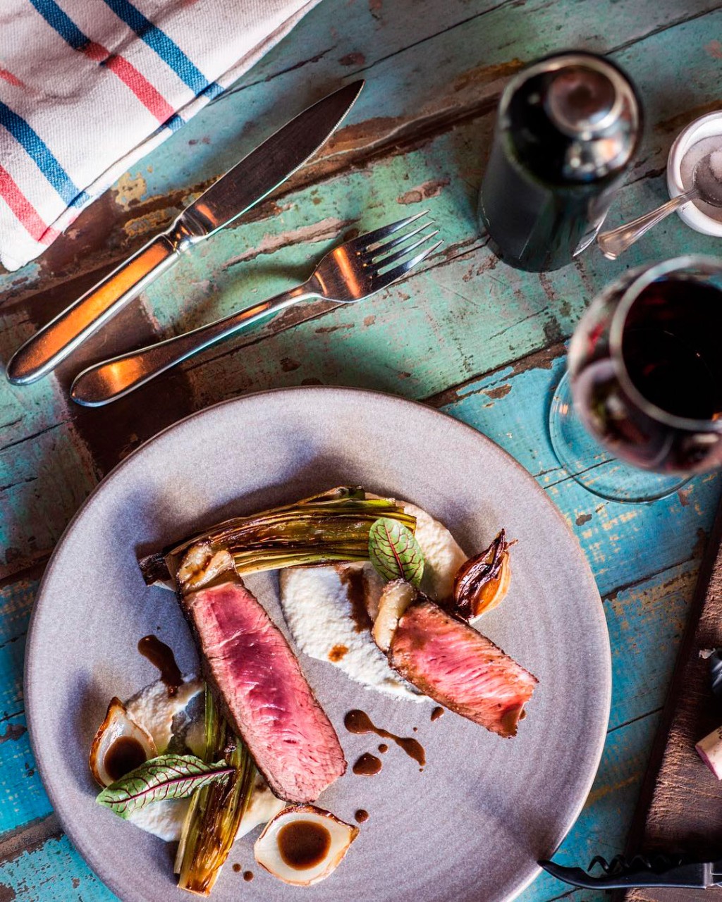 Vinho barato para churrasco com garrafas e ta&ccedil;as em cena de parrilla argentina