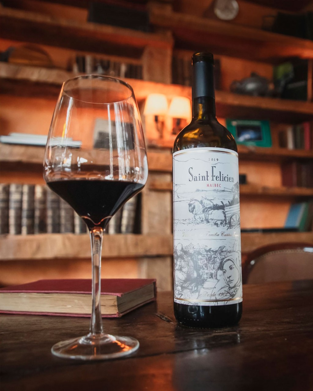 Garrafa de Saint Felicien Malbec ao lado de uma taça de vinho tinto
