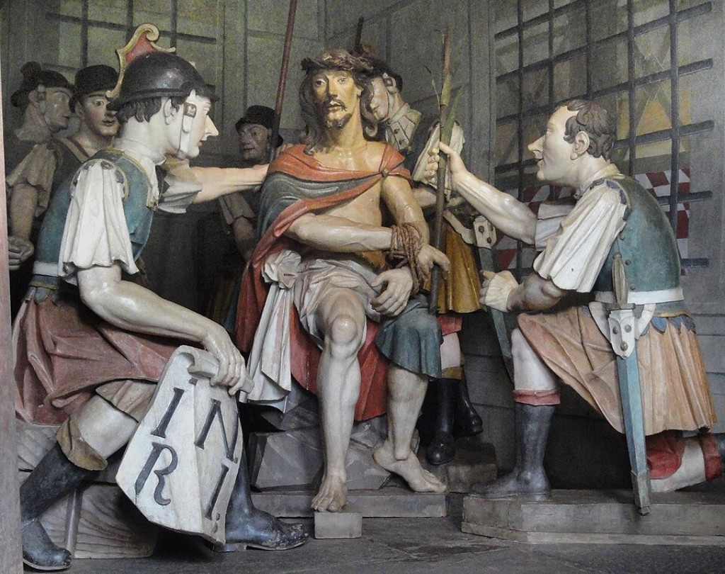 Escultura &ldquo;Jesus &eacute; Escarnecido&rdquo;, parte do conjunto dos Passos da Paix&atilde;o no Santu&aacute;rio do Bom Jesus de Matosinhos. A obra integra o c&eacute;lebre ciclo escult&oacute;rico criado por Ant&ocirc;nio Francisco Lisboa no s&eacute;culo XVIII, considerado um dos maiores marcos da arte barroca no Brasil. As figuras em madeira policromada representam a cena do esc&aacute;rnio de Cristo com forte expressividade dram&aacute;tica &mdash; caracter&iacute;stica central do barroco mineiro.