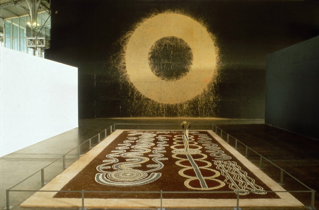 Instalação imersiva de Bill Viola apresentada em grande escala expositiva. Obras desse tipo frequentemente dependem de decisões curatoriais — como luz, som e percurso — para existir plenamente no espaço. Esse modelo levanta um debate central na arte contemporânea: até que ponto a curadoria potencializa a experiência da obra e em que momento passa a conduzir excessivamente sua leitura, deslocando a autonomia do artista para o discurso expositivo.