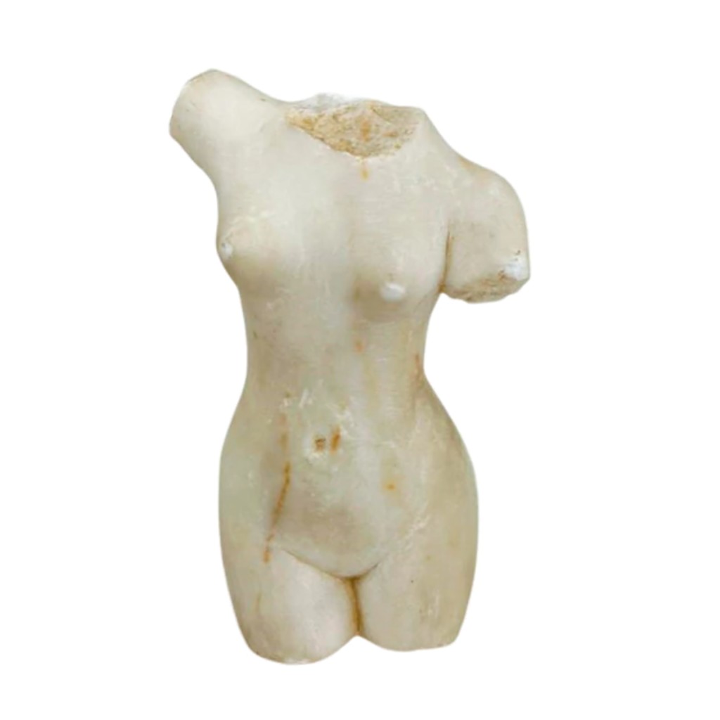 Escultura em m&aacute;rmore representando torso feminino. Europa, possivelmente s&eacute;culo XVIII/XIX. Figura de pequeno porte, com volumes suavemente modelados e p&aacute;tina antiga, evocando a tradi&ccedil;&atilde;o cl&aacute;ssica das representa&ccedil;&otilde;es do corpo feminino. A aus&ecirc;ncia de cabe&ccedil;a e membros acentua a expressividade das formas e a leitura escult&oacute;rica do torso.   