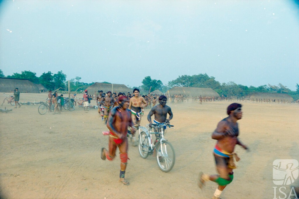 :Cena de ritual em territ&oacute;rio ind&iacute;gena do Xingu, com pintura corporal, corrida e circula&ccedil;&atilde;o coletiva no espa&ccedil;o da aldeia, evidenciando a rela&ccedil;&atilde;o entre corpo, performance e vida comunit&aacute;ria nas culturas ind&iacute;genas brasileiras
