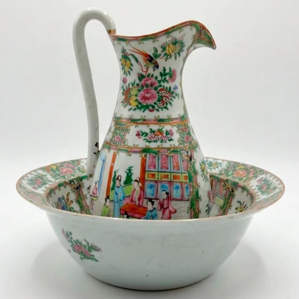 Grande jarra com bacia em porcelana de exporta&ccedil;&atilde;o chinesa, produzida durante o per&iacute;odo Daoguang (1820-1850), dinastia Qing, in&iacute;cio do s&eacute;culo XIX.   O conjunto apresenta a decora&ccedil;&atilde;o conhecida como mandarim, repert&oacute;rio desenvolvido em Cant&atilde;o no s&eacute;culo XIX, caracterizado pela combina&ccedil;&atilde;o de cenas palacianas com figuras da corte em trajes tradicionais, reservas com motivos florais, aves e insetos. A composi&ccedil;&atilde;o distribui-se em pain&eacute;is cercados por faixas decorativas em verde, dourado e rosa, organizando a superf&iacute;cie em cartelas alternadas entre cenas figurativas e buqu&ecirc;s florais.