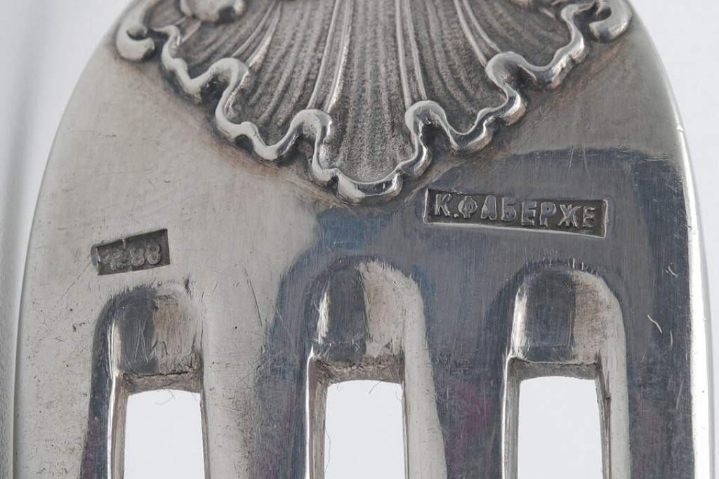 Contraste original da oficina de Karl Faberg&eacute; gravado em prata antiga, apresentando profundidade, desgaste e irregularidades naturais t&iacute;picas das t&eacute;cnicas manuais de pun&ccedil;&atilde;o utilizadas na ourivesaria hist&oacute;rica. Detalhes como esses ajudam especialistas a diferenciar pe&ccedil;as aut&ecirc;nticas de reprodu&ccedil;&otilde;es modernas.