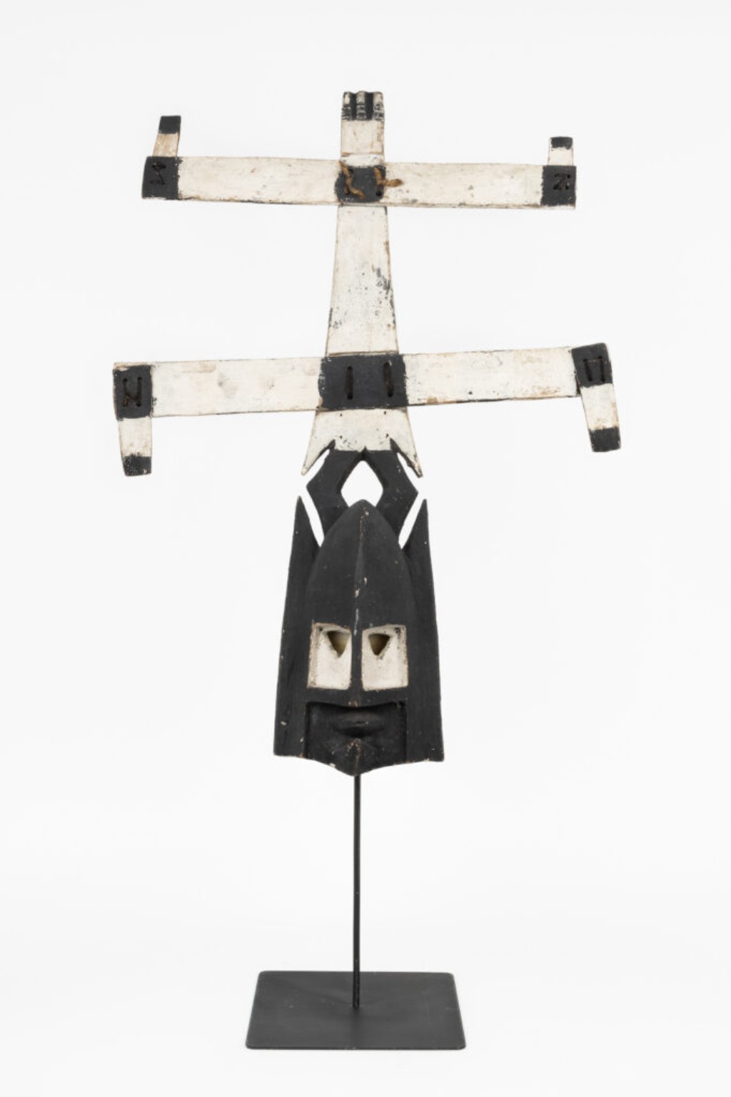 M&aacute;scara africana tradicional do povo Dogon, do Mali, utilizada em cerim&ocirc;nias rituais conhecidas como Dama, relacionadas ao culto dos ancestrais e aos ritos funer&aacute;rios. As formas geom&eacute;tricas alongadas e a composi&ccedil;&atilde;o vertical caracter&iacute;stica refletem a cosmologia Dogon e a forte dimens&atilde;o espiritual presente na arte ritual africana.