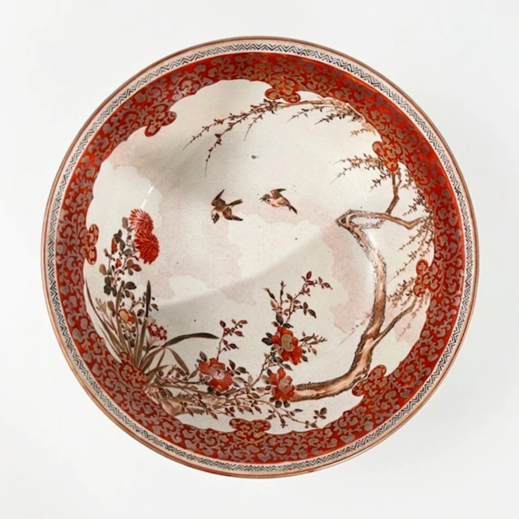 Bowl em porcelana Kutani policromada e dourada, Jap&atilde;o, per&iacute;odo Edo, s&eacute;culo XIX. O interior apresenta cena naturalista de p&aacute;ssaros em voo entre ramos floridos e cris&acirc;ntemos, pintada &agrave; m&atilde;o em vermelho ferrugem, ocre e dourado sobre fundo branco.