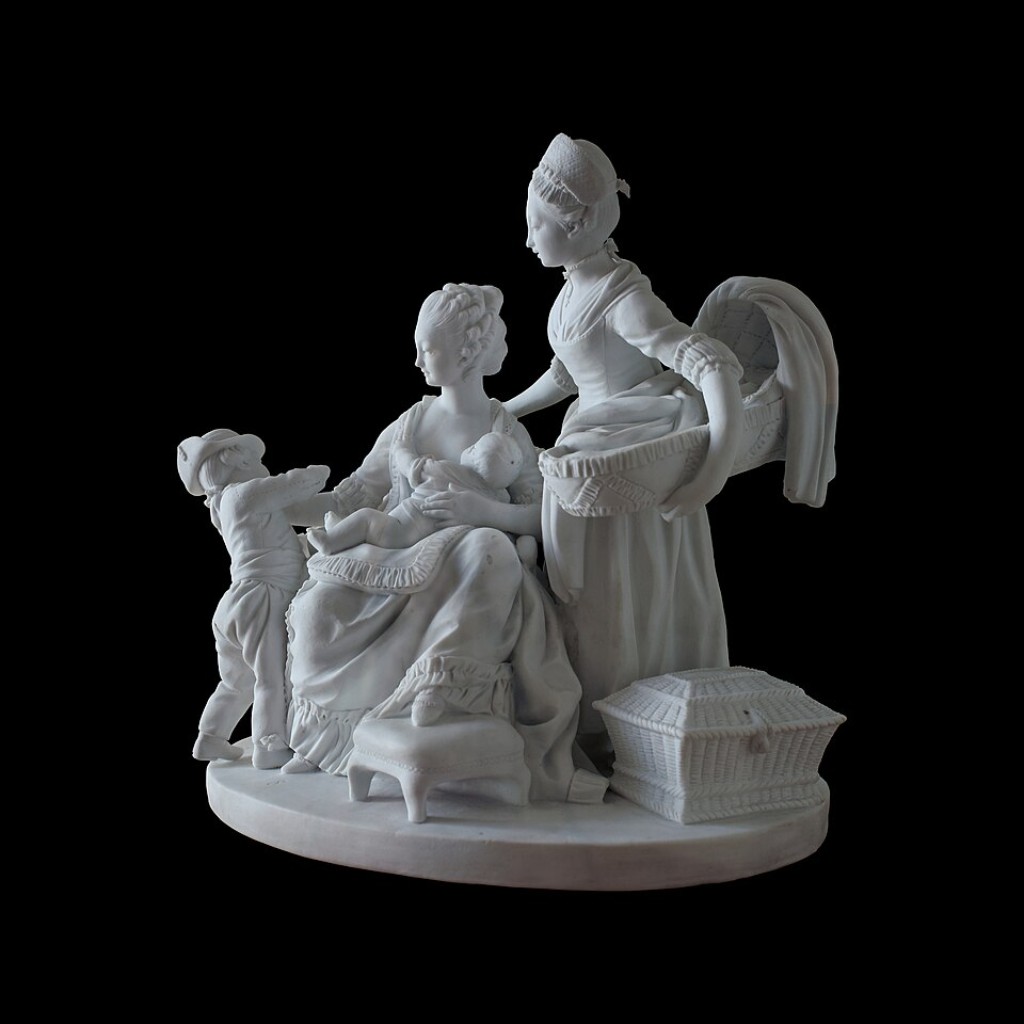 **&ldquo;La Nourrice&rdquo; (A Ama de Leite), grupo escult&oacute;rico em biscuit de S&egrave;vres criado a partir de modelo de Louis-Simon Boizot e produzido pela c&eacute;lebre manufatura francesa no final do s&eacute;culo XVIII. Executada em porcelana biscuit &mdash; caracterizada pela aus&ecirc;ncia de esmalte brilhante e pela apar&ecirc;ncia semelhante ao m&aacute;rmore esculpido &mdash; a obra demonstra o elevado n&iacute;vel t&eacute;cnico alcan&ccedil;ado por S&egrave;vres durante o per&iacute;odo neocl&aacute;ssico. Inspirada nos ideais de sensibilidade, maternidade e vida dom&eacute;stica valorizados pela sociedade francesa da &eacute;poca, a composi&ccedil;&atilde;o apresenta delicados detalhes anat&ocirc;micos, drapeados refinados e uma not&aacute;vel sensa&ccedil;&atilde;o de movimento. Esculturas como esta revelam como a manufatura expandiu sua produ&ccedil;&atilde;o para al&eacute;m de vasos e servi&ccedil;os de mesa, tornando-se tamb&eacute;m um importante centro de cria&ccedil;&atilde;o art&iacute;stica e escult&oacute;rica. Atualmente, exemplares desse tipo figuram entre as obras mais admiradas da porcelana europeia, sendo preservados em importantes museus e cole&ccedil;&otilde;es hist&oacute;ricas.**