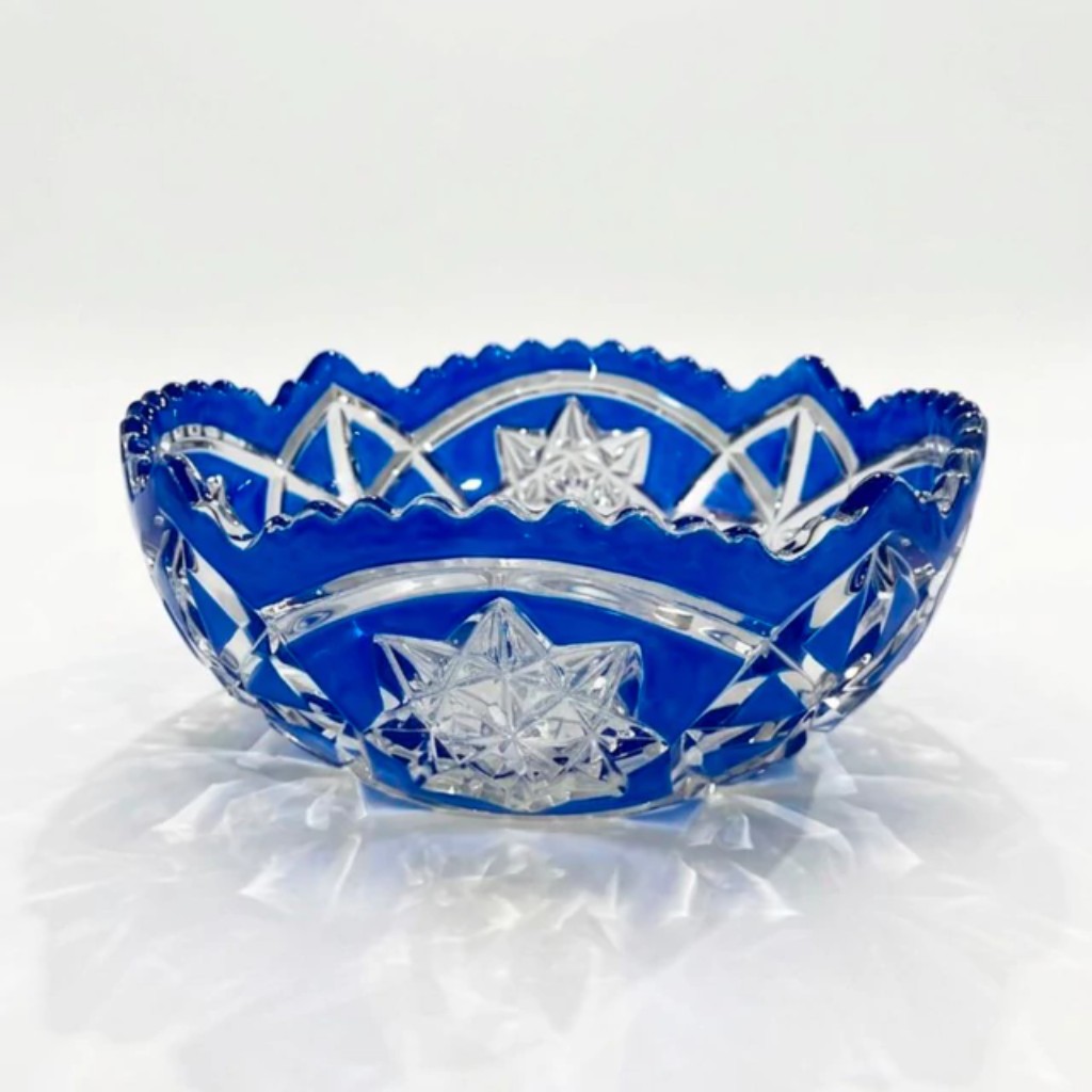 Conjunto de cinco bowls em cristal da Bo&ecirc;mia (regi&atilde;o da atual Rep&uacute;blica Tcheca, cuja tradi&ccedil;&atilde;o cristaleira remonta ao s&eacute;culo XIII e &eacute; considerada uma das mais prestigiosas do mundo) trabalhados na refinada t&eacute;cnica overlay, com sobreposi&ccedil;&atilde;o de camada em azul cobalto sobre cristal transparente e lapida&ccedil;&atilde;o manual em motivos de estrelas, losangos e bordas recortadas em fest&atilde;o.  O virtuoso trabalho artesanal, ao revelar o cristal incolor sob a camada colorida, cria o contraste bicolor que consagrou a manufatura bo&ecirc;mia como refer&ecirc;ncia m&aacute;xima da cristaleria europeia. Composto por uma bowl maior e quatro menor