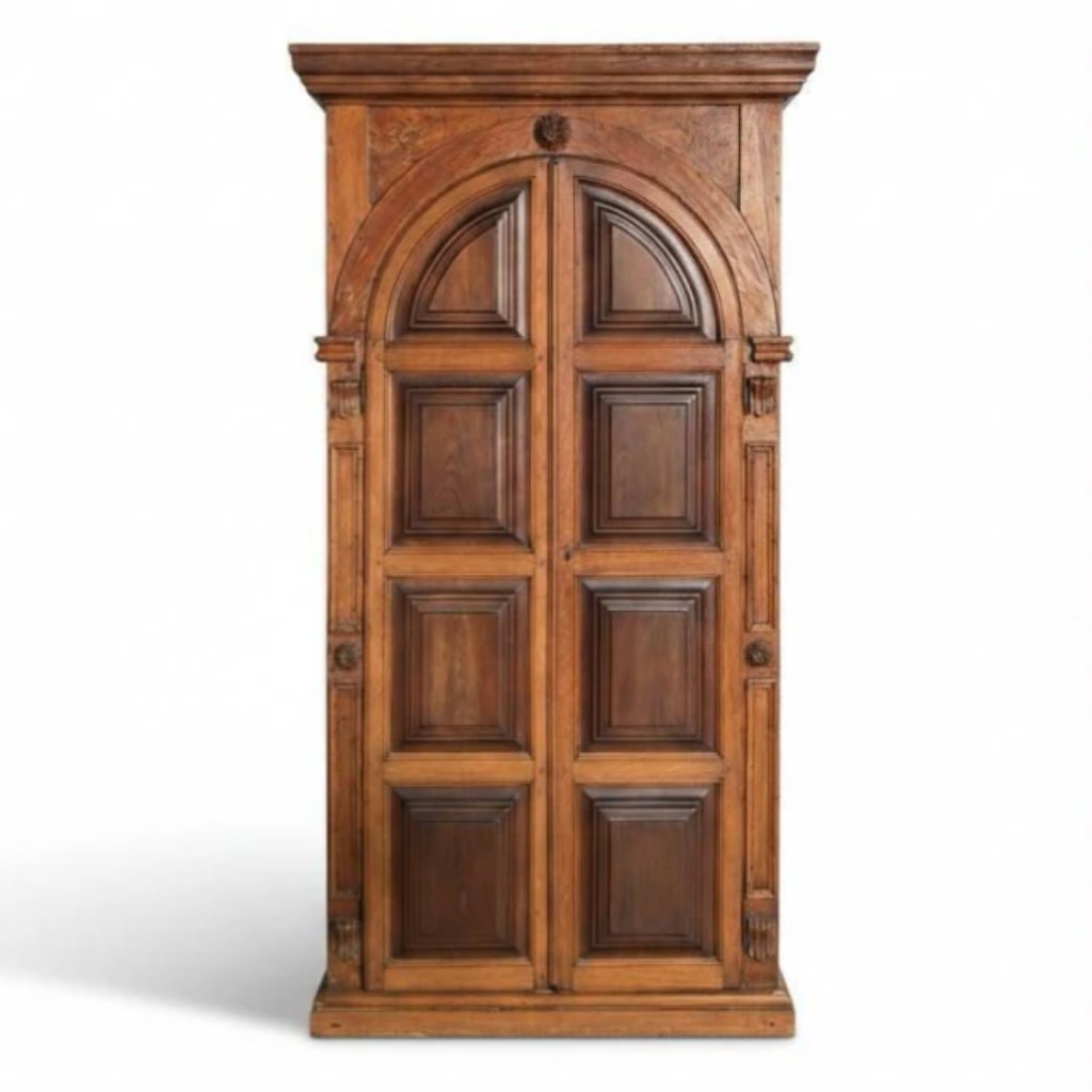 Grande armário ermida executado em vinhático e jacarandá da Bahia, com portas em arco pleno almofadadas em vários módulos simulando a fachada de uma ermida. Laterais também trabalhadas em painéis almofadados com arco superior, mantendo o mesmo vocabulário arquitetônico. Obra brasileira do século XVIII/XIX, de excelente qualidade de marcenaria, peça de alto valor histórico e decorativo. O "armário-ermida" é uma tipologia singular do mobiliário luso-brasileiro dos séculos XVIII e XIX, que combinava a função utilitária do armário (guarda de roupas, louças ou objetos litúrgicos) com a linguagem arquitetônica de uma capela em miniatura, daí o nome ermida (pequena capela ou oratório)