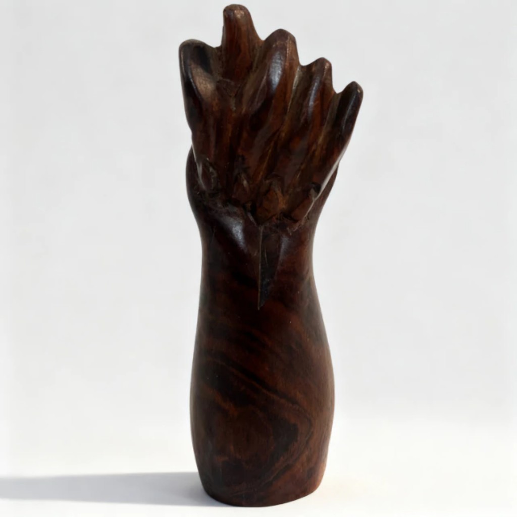 Esta escultura em jacarandá é uma belíssima representação da arte popular, trazendo a força e o simbolismo da tradicional figa. Com suas dimensões compactas de 13 x 4 x 4 cm, a peça impressiona pela riqueza dos detalhes esculpidos à mão e pela sofisticação da madeira nobre. Os veios naturais e a tonalidade escura do jacarandá ganham vida através de um acabamento polido e acetinado, destacando o design anatômico que une misticismo, proteção e a pura identidade do artesanato brasileiro em uma obra única e cheia de história.