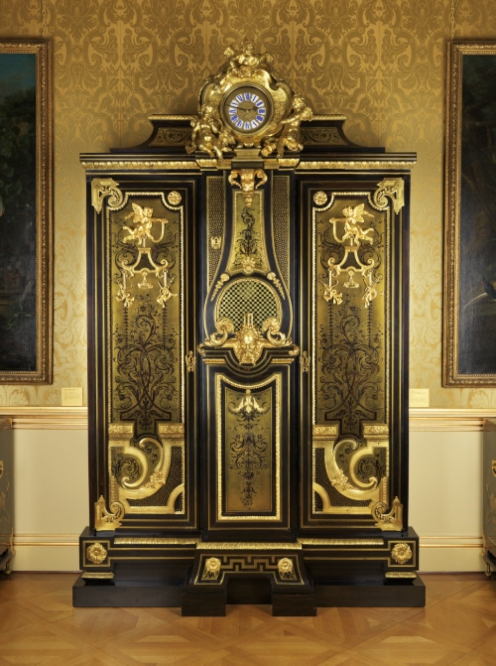 Junto com sua peça complementar em marchetaria premier-partie, esse guarda-roupa foi listado na oficina do grande marceneiro André-Charles Boulle em outubro de 1715, quando ele entregou sua oficina aos filhos. É revestida com marquetaria contre-partie, com o desenho em casca de tartaruga sobre um fundo de latão, e era valorizada por menos do que sua companheira, onde a carapaça serve de fundo, refletindo o menor custo do revestimento de latão em comparação com o carapaça.