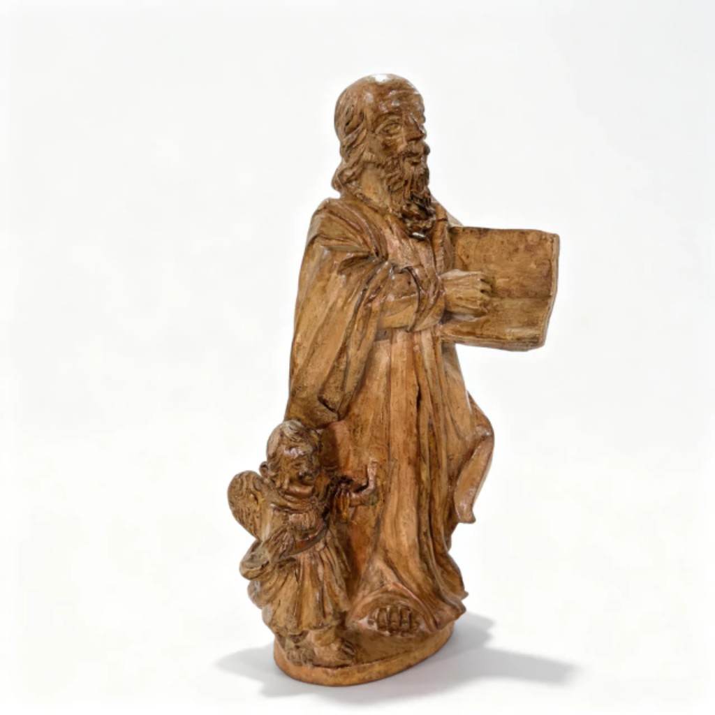 Imagem de S&atilde;o Mateus em terracota de produ&ccedil;&atilde;o portuguesa do s&eacute;culo XVIII, representando o evangelista barbado em p&eacute;, segurando o livro do Evangelho com o anjo a seus p&eacute;s, atributos iconogr&aacute;ficos tradicionais que identificam o santo. A pe&ccedil;a apresenta apurado tratamento dos drapeados em movimento e expressividade naturalista do rosto, integrando a tradi&ccedil;&atilde;o da imagin&aacute;ria sacra portuguesa do per&iacute;odo