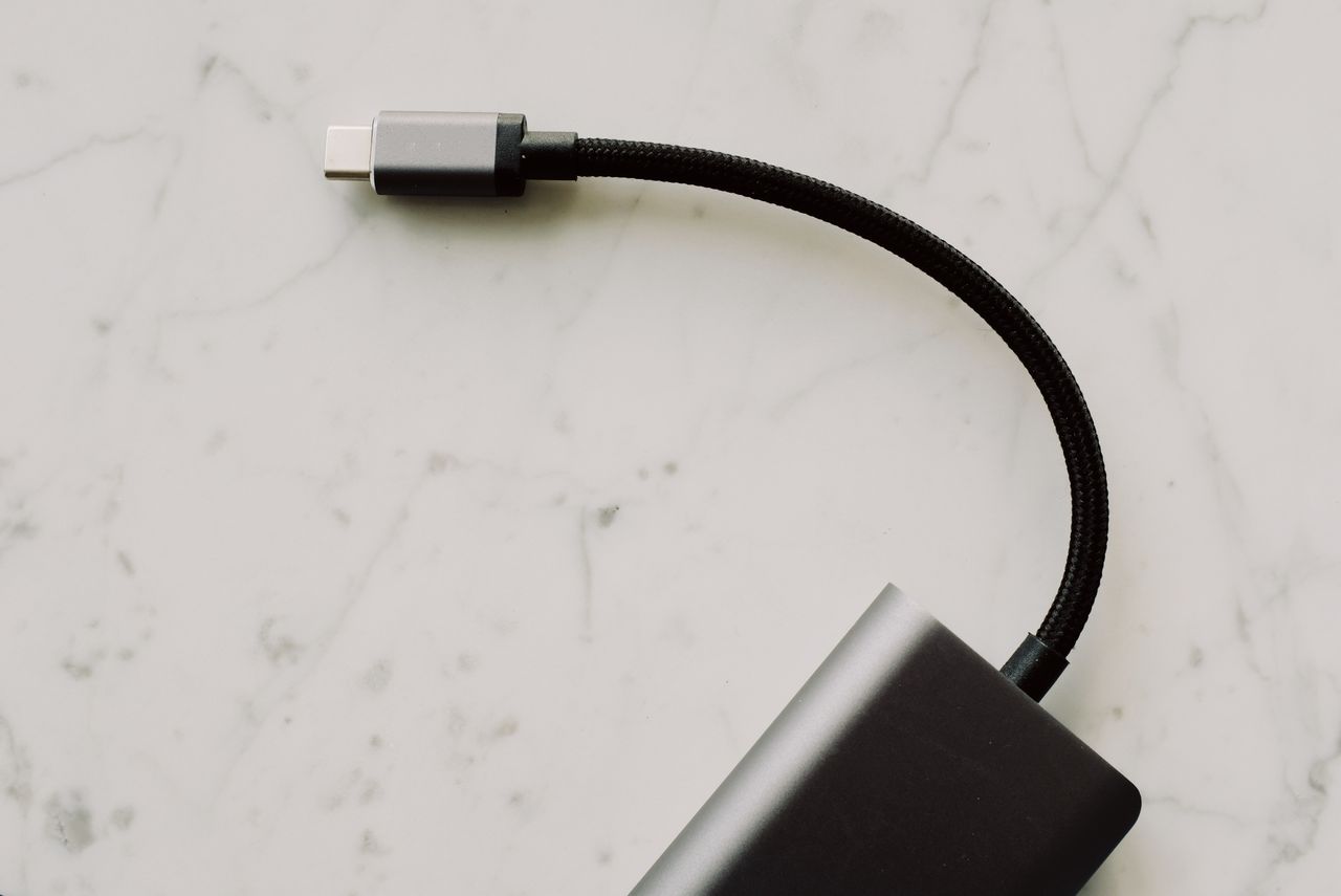 Varios cables USB-C para iPhone ordenados sobre superficie neutra mostrando diferencias de calidad