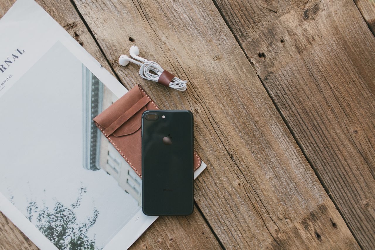 Funda de cuero para iPhone sobre escritorio de trabajo de un creador de contenido