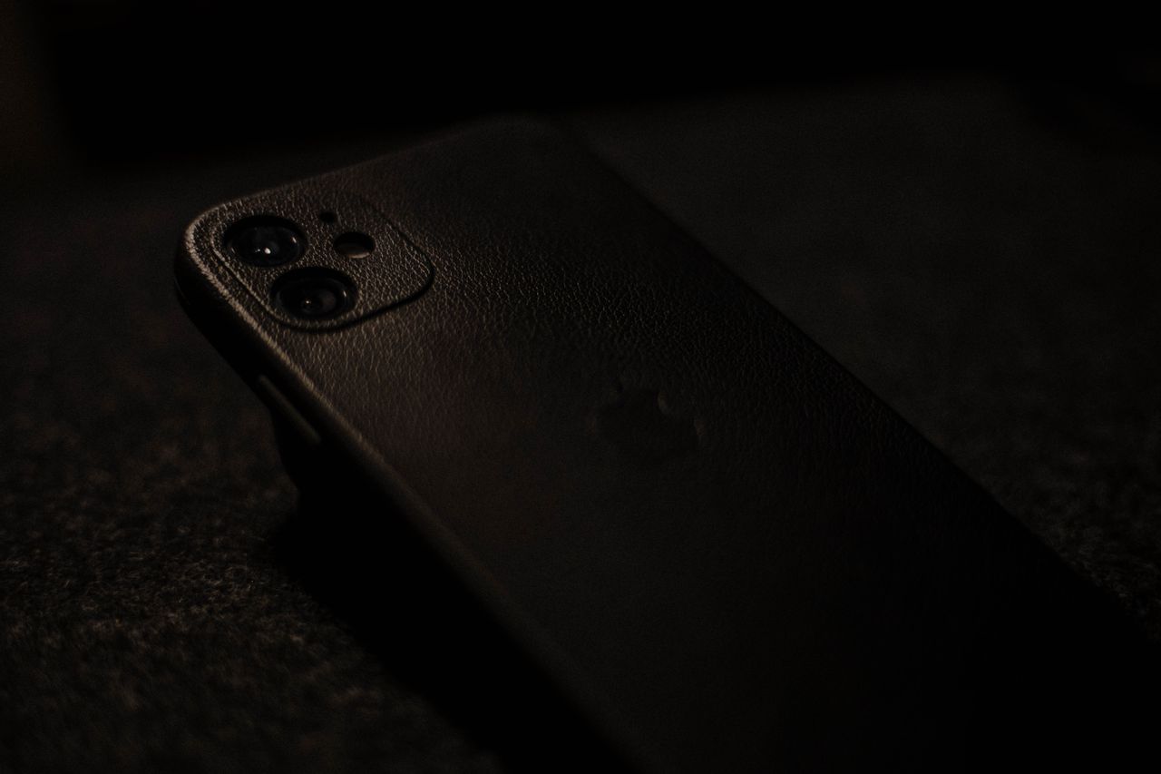 Funda de cuero para iPhone sobre escritorio, accesorio premium que acompaña Apple Intelligence