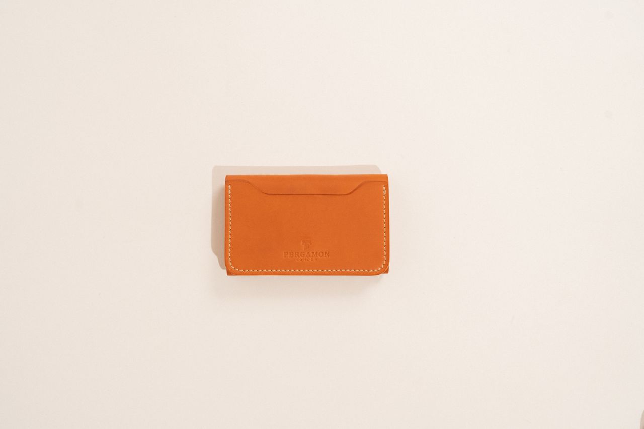 Accesorios de cuero premium junto a un iPhone, ilustrando la propuesta de funda de cuero para iPhone