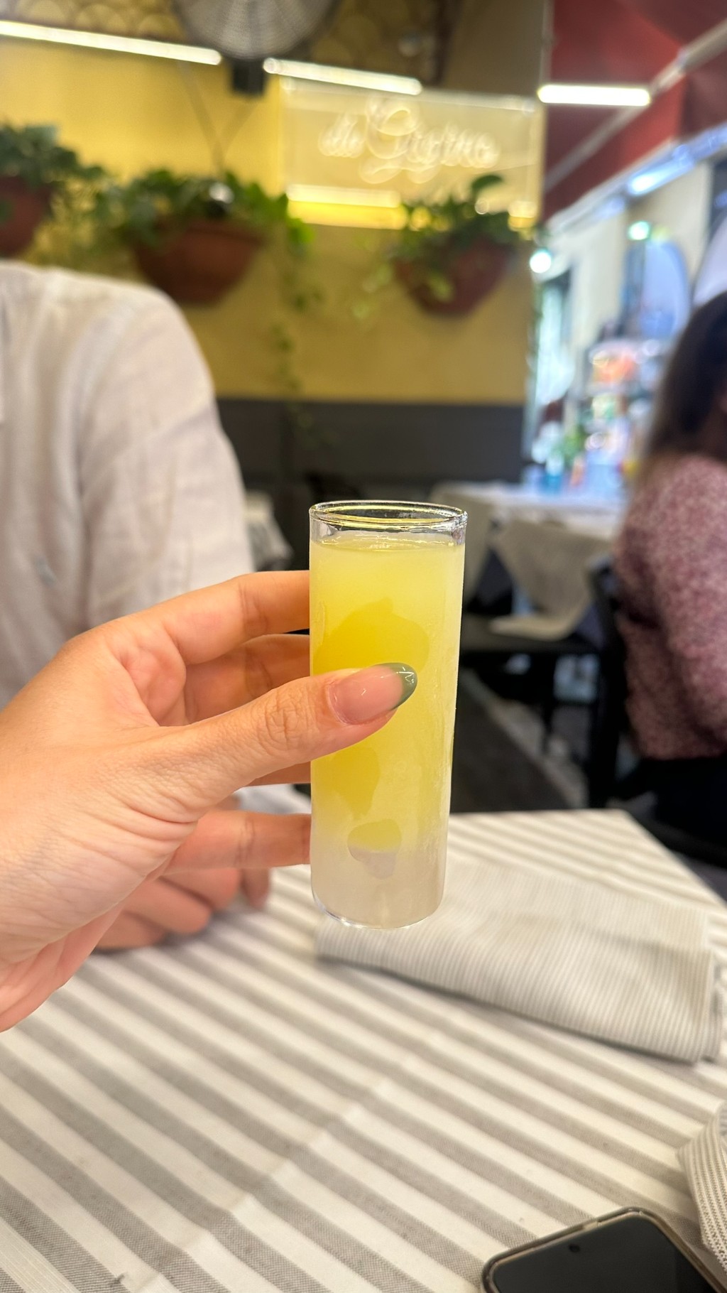 Dose de limoncello gelado servida em mesa italiana com amigos