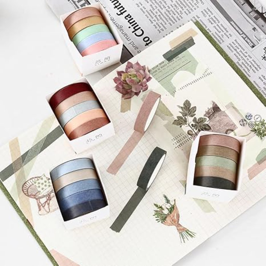 Rollos de washi tape en colores neutros lisos aplicados sobre hojas de cuaderno.
