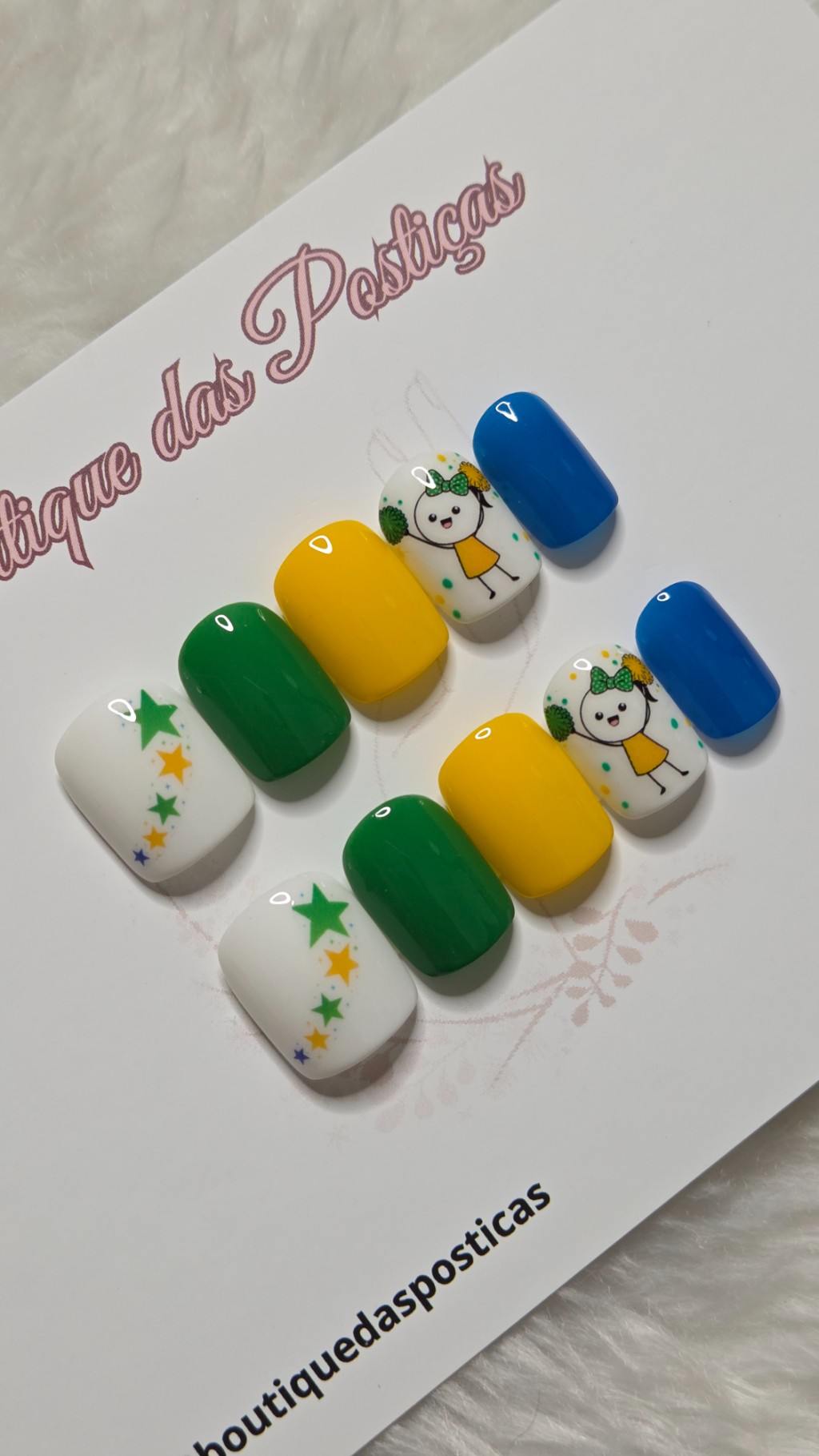 Kit de unhas posti&ccedil;as decoradas nas cores verde, amarelo, azul e branco com estrelas e personagem delicada inspirada no Brasil.