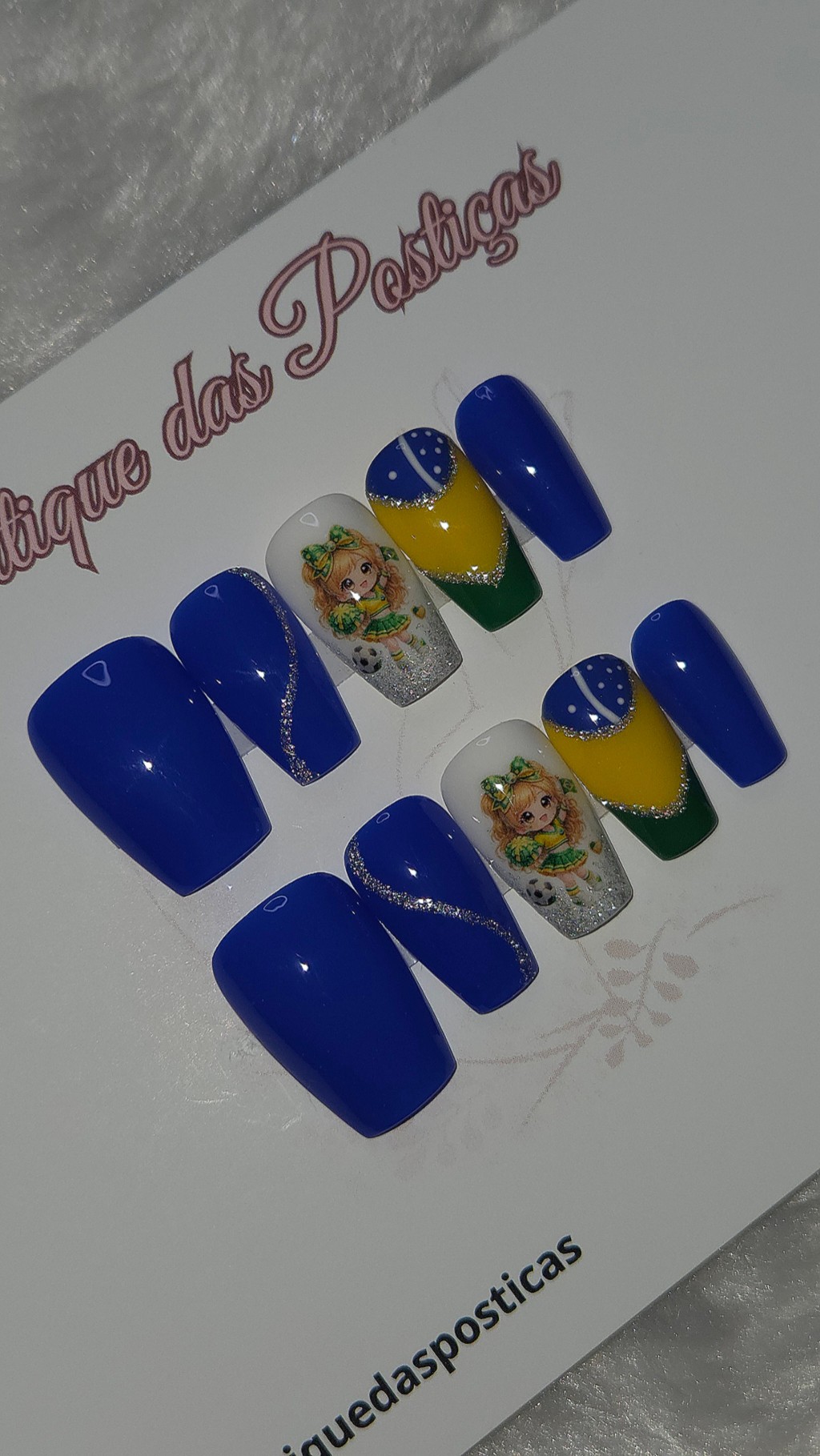 Kit de unhas posti&ccedil;as decoradas em azul, amarelo, verde e branco com glitter prateado hologr&aacute;fico, personagem delicada e detalhes inspirados na bandeira do Brasil.