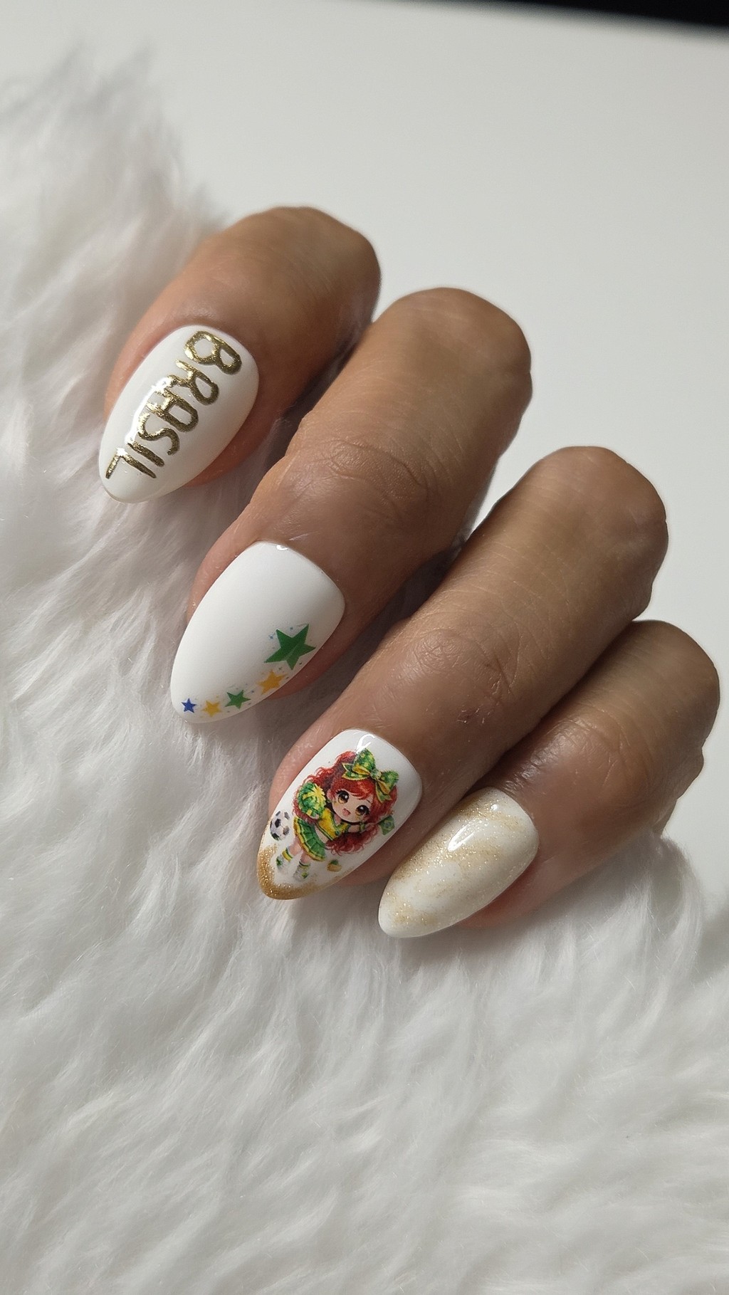 Unhas posti&ccedil;as decoradas em close com esmalta&ccedil;&atilde;o branca, glitter dourado suave, estrelas coloridas e nail art tem&aacute;tica do Brasil