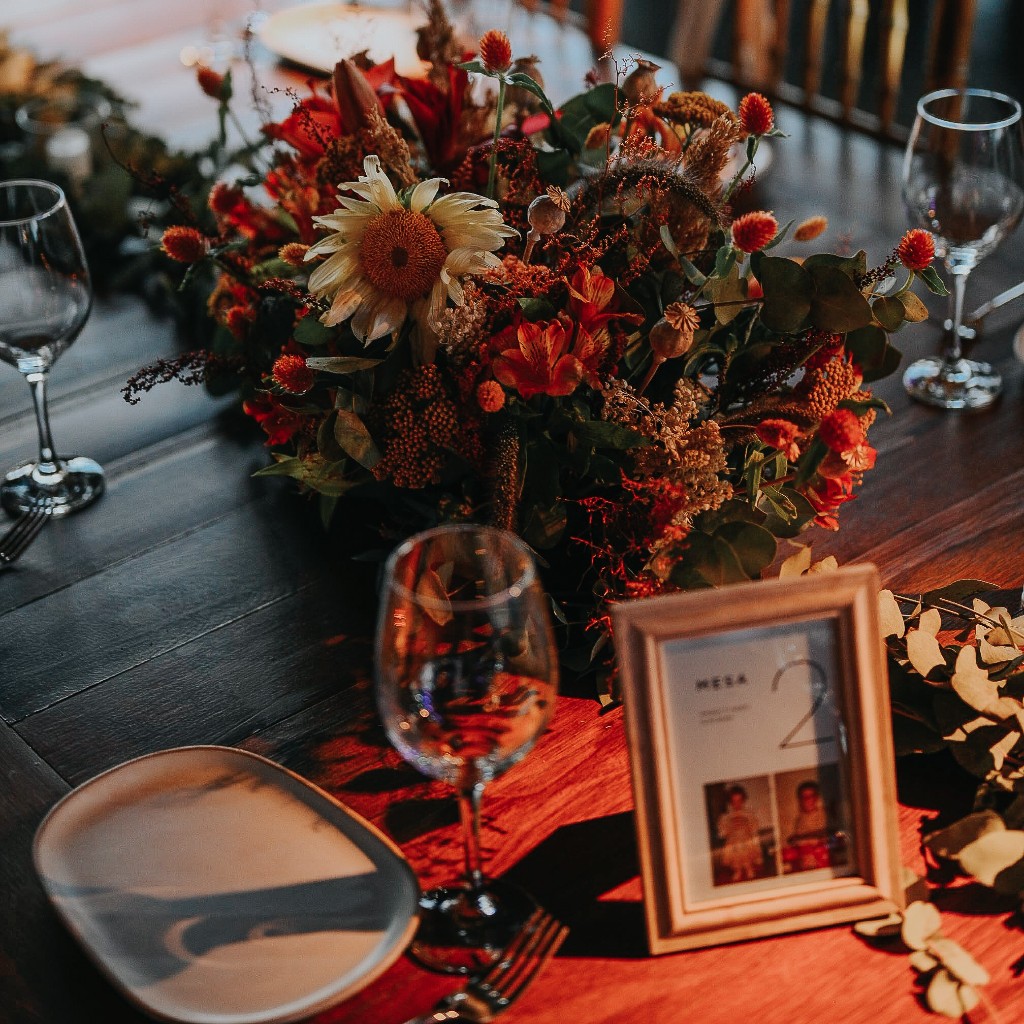 Mesa ambientada con flores, vajilla y cristalería para una celebración