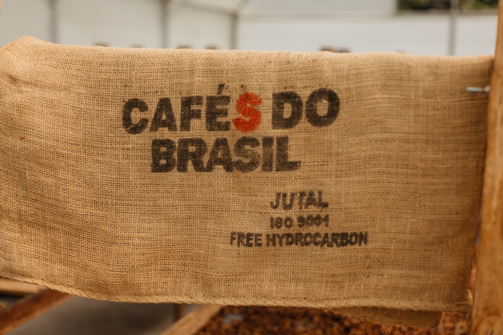 Saca de juta com a inscri&ccedil;&atilde;o Caf&eacute;s do Brasil sobre caf&eacute; secando
