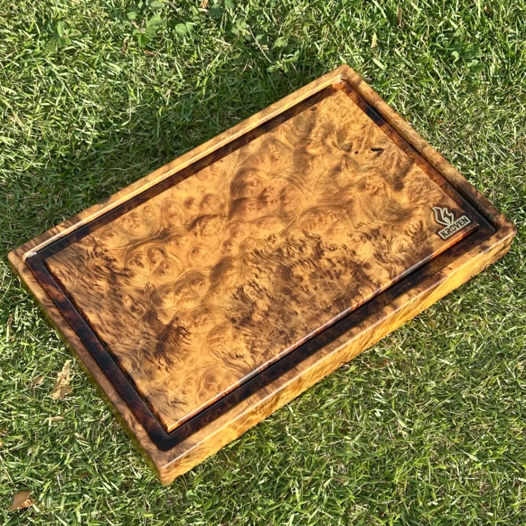 T&aacute;bua de churrasco Kroven em madeira nobre tipo Burl, apresentando desenhos org&acirc;nicos &uacute;nicos e fibras densas de madeira maci&ccedil;a de alta resist&ecirc;ncia.