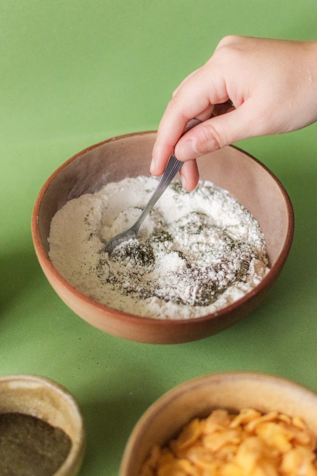 Mano mezclando stevia en polvo con harina en un bowl