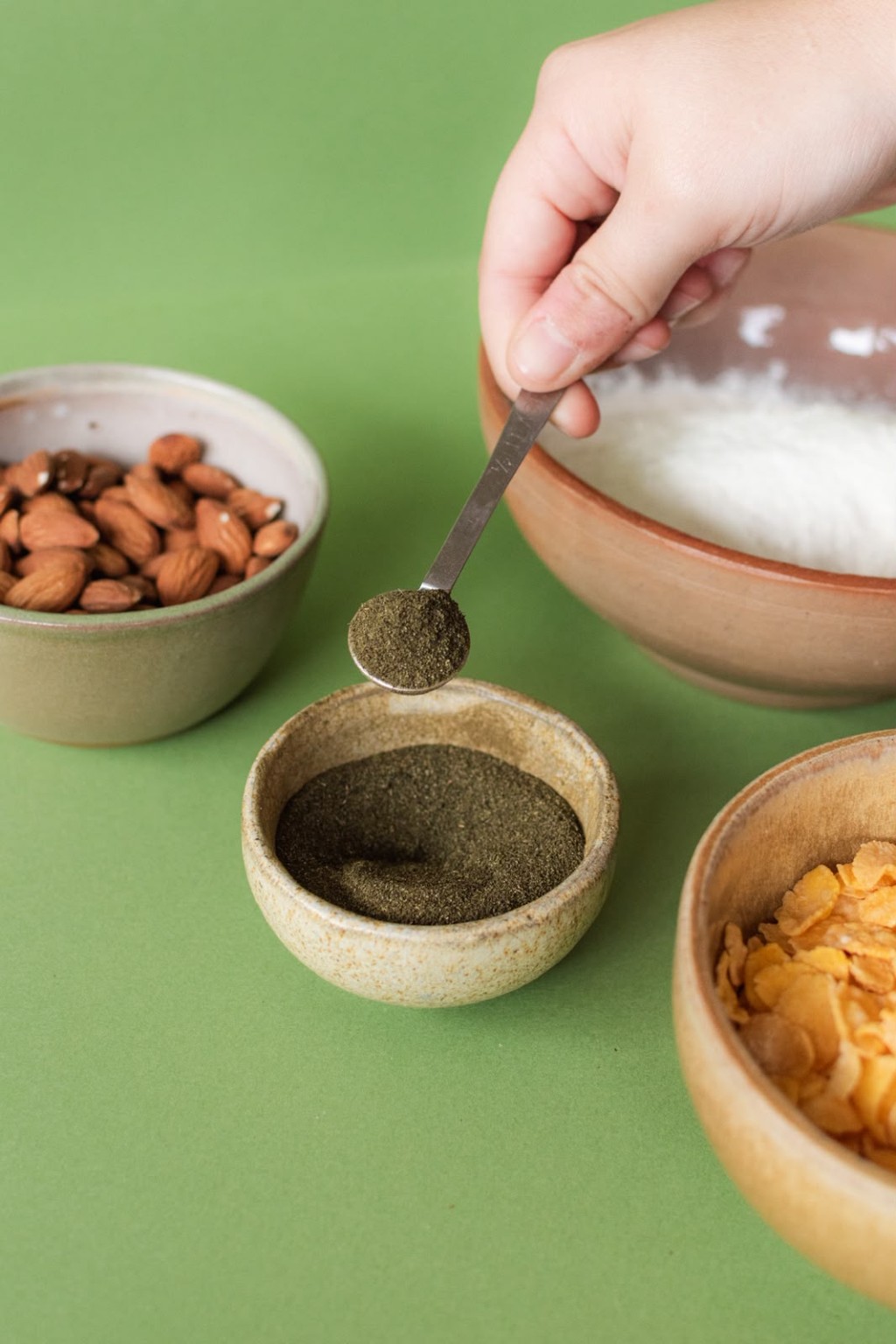 Cuchara con stevia natural en polvo sobre un bowl, junto a frutos secos y cereales